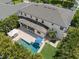Aerial view of the home with a pool, spa, covered patio, and lush tropical landscaping at 5025 W Homer Ave, Tampa, FL 33629