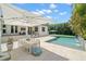 Beautiful backyard with an in-ground pool, travertine pavers, patio dining set, and lounge area at 5025 W Homer Ave, Tampa, FL 33629