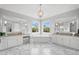 Bright bathroom featuring dual vanities, soaking tub, marble floors, and elegant chandelier lighting at 5025 W Homer Ave, Tampa, FL 33629