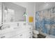Bright bathroom featuring vanity and sink, a decorative mirror, and a stylish shower curtain at 5025 W Homer Ave, Tampa, FL 33629