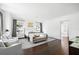 Bright bedroom features hardwood floors, neutral furniture, and large windows with decorative curtains at 5025 W Homer Ave, Tampa, FL 33629