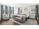 Well-lit bedroom showcasing hardwood floors, neutral decor, plush seating, and ample natural light at 5025 W Homer Ave, Tampa, FL 33629