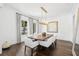 Elegant dining room with modern decor featuring a large table, striking chandelier, and hardwood flooring at 5025 W Homer Ave, Tampa, FL 33629
