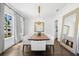 Bright dining room featuring a large dining table, modern chandelier, and hardwood floors at 5025 W Homer Ave, Tampa, FL 33629