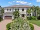 Stunning home with a lush, landscaped front yard, circular driveway, and beautiful palm trees at 5025 W Homer Ave, Tampa, FL 33629