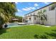 Expansive home exterior shows manicured lawn, large pool, and rear building facade at 5025 W Homer Ave, Tampa, FL 33629