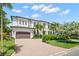 Spacious home featuring a two-car garage, a circular driveway, and mature landscaping at 5025 W Homer Ave, Tampa, FL 33629