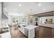 Bright open kitchen with hardwood floors, marble counters, island, stainless steel appliances, and eat in area at 5025 W Homer Ave, Tampa, FL 33629