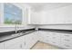 Bright laundry room featuring white cabinets, a black countertop, and a large window at 5025 W Homer Ave, Tampa, FL 33629