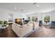 Open-concept living room featuring hardwood floors, neutral furniture, and multiple windows with views at 5025 W Homer Ave, Tampa, FL 33629