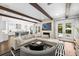 Open-concept living room with wooden beams and access to the backyard, kitchen, and fireplace at 5025 W Homer Ave, Tampa, FL 33629