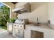 Outdoor kitchen with built-in grill, sink, refrigerator and counter space at 5025 W Homer Ave, Tampa, FL 33629