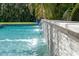 Close up of the tranquil in-ground pool with a waterfall feature spilling into the clear blue water at 5025 W Homer Ave, Tampa, FL 33629
