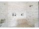 Walk-in shower with beautiful marble tiling, a rainfall showerhead, and built-in shelves at 5025 W Homer Ave, Tampa, FL 33629