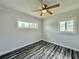 Bright bedroom featuring wood-look floors, new windows and a ceiling fan at 5043 Osprey Ln, New Port Richey, FL 34652