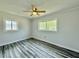 Light-filled bedroom featuring new windows, wood-look floors, and ceiling fan at 5043 Osprey Ln, New Port Richey, FL 34652