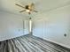 Relaxing bedroom featuring wood-look floors, a ceiling fan, closet, and white walls at 5043 Osprey Ln, New Port Richey, FL 34652