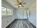 Cozy bedroom featuring new windows, wood-look floors, ceiling fan, and closet at 5043 Osprey Ln, New Port Richey, FL 34652