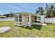 Cozy home exterior with a well-maintained lawn, bay window, covered carport, and white picket fence at 5043 Osprey Ln, New Port Richey, FL 34652