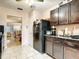 A kitchen with dark wood cabinets and black appliances, leading into a dining and living area at 5150 10Th N Ave # 302, St Petersburg, FL 33710