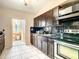 A kitchen featuring dark wood cabinets, tile backsplash, stainless steel oven and sink at 5150 10Th N Ave # 302, St Petersburg, FL 33710