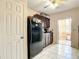 View of the kitchen with a refrigerator and cabinets with dark wood paneling and a white tiled floor at 5150 10Th N Ave # 302, St Petersburg, FL 33710
