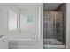 Modern bathroom with a soaking tub and a glass-enclosed shower with designer tile and a built-in niche at 5938 164Th E Ave, Parrish, FL 34219