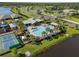 Aerial view of community pool, tennis courts, and playground by the lake at 5938 164Th E Ave, Parrish, FL 34219