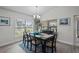Bright dining room with a large window, stylish chandelier, and an elegant black table set for six at 5938 164Th E Ave, Parrish, FL 34219