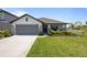 Charming single-story home with well-maintained landscaping, a gray roof and an attached garage at 5938 164Th E Ave, Parrish, FL 34219