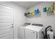 A well-organized laundry room with a washer, dryer, shelving, and a door at 5938 164Th E Ave, Parrish, FL 34219