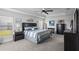 Calm main bedroom with a tray ceiling, ceiling fan, plush carpet, and a large window for natural light at 5938 164Th E Ave, Parrish, FL 34219