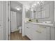 Bright bathroom featuring a white vanity with gold hardware and a shower with marble-look tile at 6051 Sun Blvd # 111, St Petersburg, FL 33715