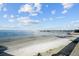 Sandy beach meets the ocean with views of a pier extending into the distance under a blue sky at 6051 Sun Blvd # 111, St Petersburg, FL 33715