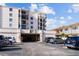 Condominium building with covered parking and black metal balcony railings under a partly cloudy sky at 6051 Sun Blvd # 111, St Petersburg, FL 33715