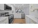 Well-lit kitchen featuring quartz countertops, stainless appliances, an open design to the living space, and modern white cabinetry at 6051 Sun Blvd # 111, St Petersburg, FL 33715