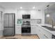 Modern kitchen featuring white cabinets, stainless steel appliances, quartz countertops, and ample storage for culinary enthusiasts at 6051 Sun Blvd # 111, St Petersburg, FL 33715