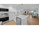 Updated kitchen featuring stainless steel appliances, quartz countertops, and an open layout leading to the dining and living areas at 6051 Sun Blvd # 111, St Petersburg, FL 33715
