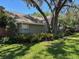 View of a well-maintained backyard showing mature trees and lush plants at 6805 Monet Cir, Temple Terrace, FL 33617