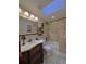 Cozy bathroom featuring a vanity, toilet, and shower-tub combo beneath a skylight at 6805 Monet Cir, Temple Terrace, FL 33617