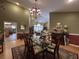 Elegant dining room featuring a glass table, decorative chandelier, and classic rug at 6805 Monet Cir, Temple Terrace, FL 33617