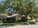 Charming suburban home featuring a mature oak tree in a landscaped yard at 6805 Monet Cir, Temple Terrace, FL 33617