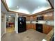 Updated kitchen with stainless appliances, tiled backsplash, and seamless flow to dining area at 6805 Monet Cir, Temple Terrace, FL 33617