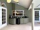 Outdoor kitchen featuring a bar with sink, cabinets, and stylish doors at 6805 Monet Cir, Temple Terrace, FL 33617