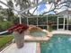 Inviting pool with waterfall feature, covered lanai, and lush landscaping create a serene outdoor oasis at 6805 Monet Cir, Temple Terrace, FL 33617