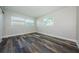 Bright bedroom featuring wood-look flooring and natural light from two windows at 6935 Monte Carlo N, Pinellas Park, FL 33781