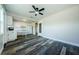 A bright, open-concept living room with a ceiling fan, wood-look floors, and access to the kitchen at 6935 Monte Carlo N, Pinellas Park, FL 33781