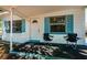 Welcoming covered front porch featuring two chairs, white posts, and white trim with blue accents at 7051 Dartmouth N Ave, St Petersburg, FL 33710