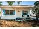 Inviting front porch with seating and white door, complemented by blue trim and white exterior at 7051 Dartmouth N Ave, St Petersburg, FL 33710