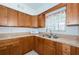Kitchen with wood cabinets, laminate countertop, double sink and white appliances at 7051 Dartmouth N Ave, St Petersburg, FL 33710